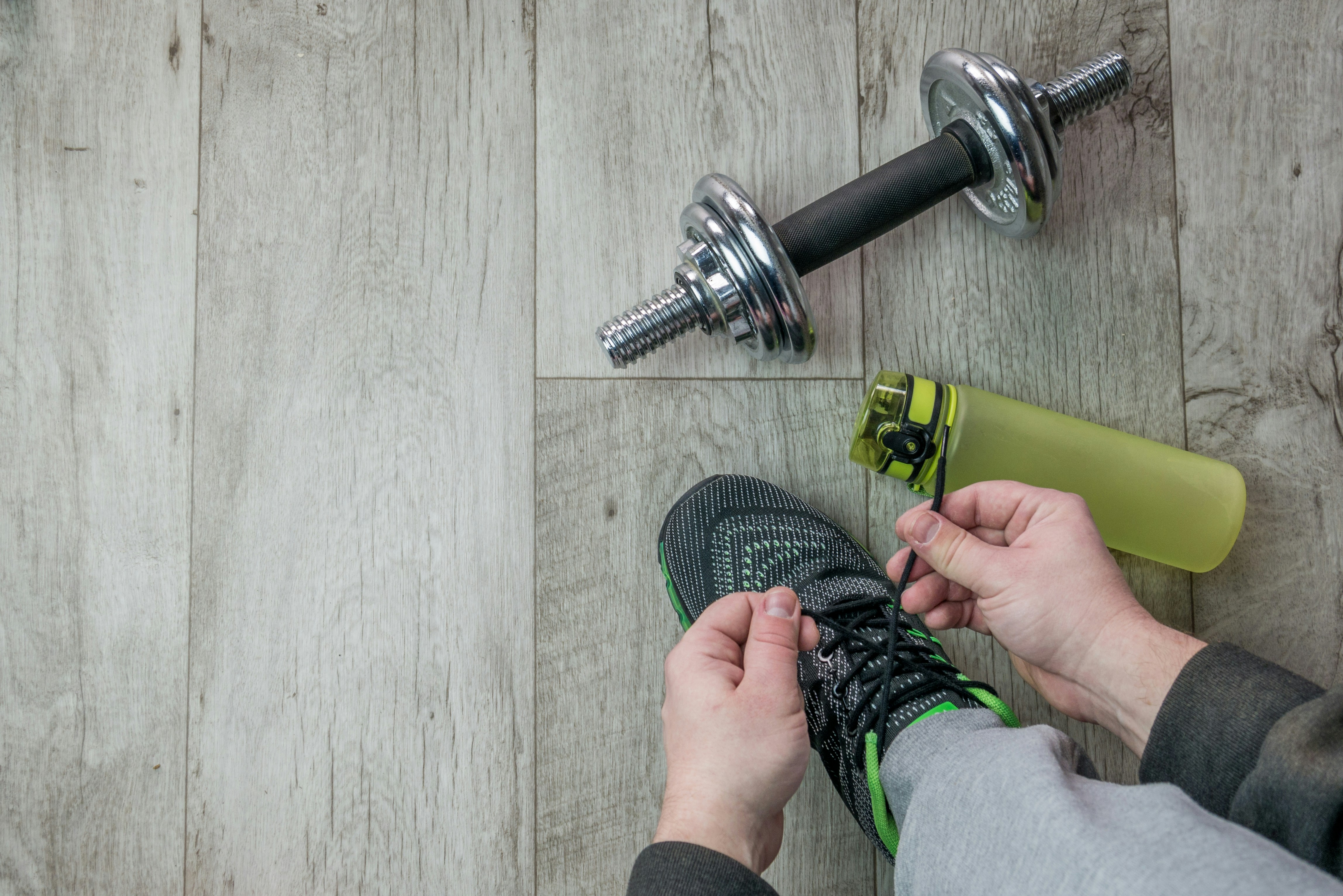 Fitness objects isolated on wooden background. Gray Sneakers, dumbbells and water bottle. Active, healthy lifestyle, sport, fitness, and objects concept. More of my photos and videos Adobe Stock:http://bit.ly/3RqlciK More of my photos and videos Shutterstock: https://www.shutterstock.com/g/ALEKSANDRBERDYUGIN My email: bermix999@gmail.com